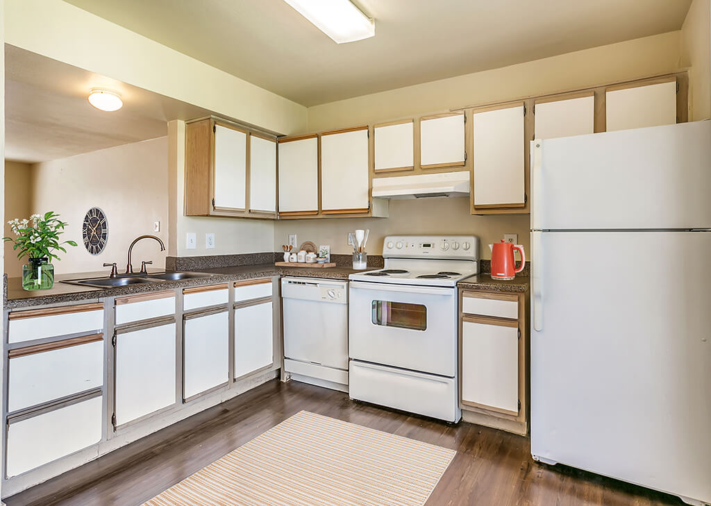 A light kitchen with hardwood floors at Paradise Oak Apartments in Austin, Texas.